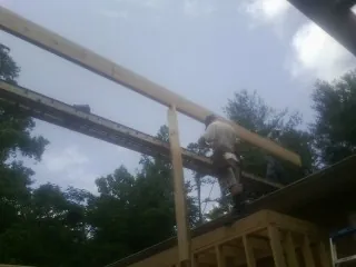 Carpenter setting a ridge beam over a new addition frame — Ice Dam Removal by Roofing Brothers in Norco