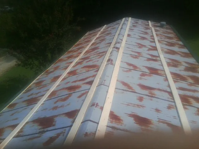 Rusted metal roof panels with new wood purlins before replacement — Storm Damage Roof Repair in Norco by Roofing Brothers